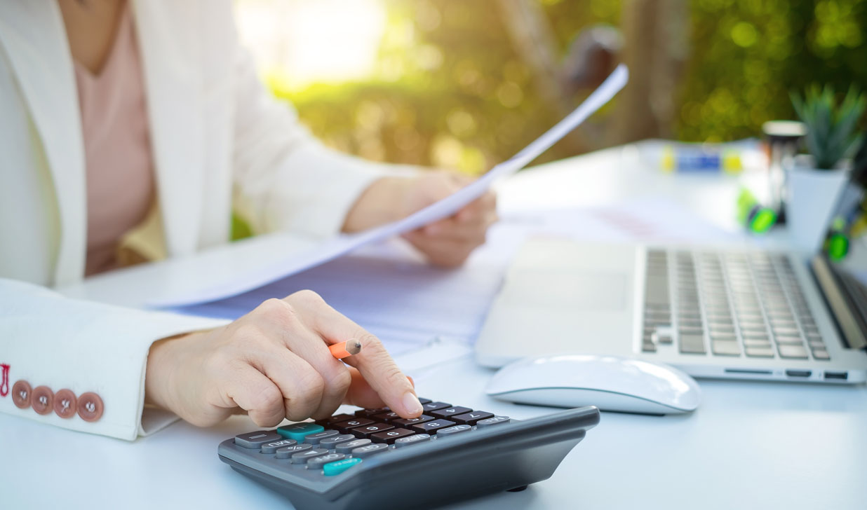 Business woman using a calculator to calculate